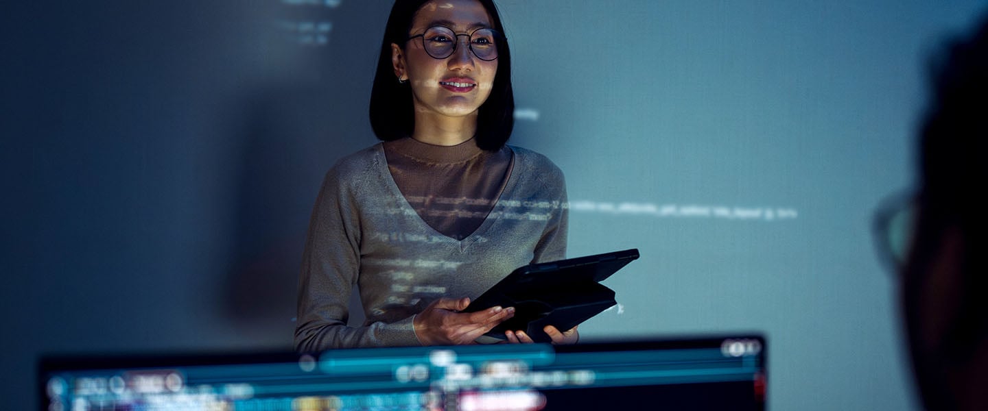 Mulher em frente a telas de tecnologia