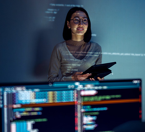 Mulher em frente a telas de tecnologia