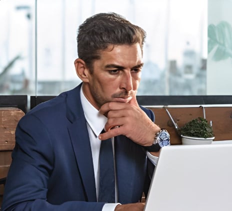 Homem de terno ajustando notas em notebook 