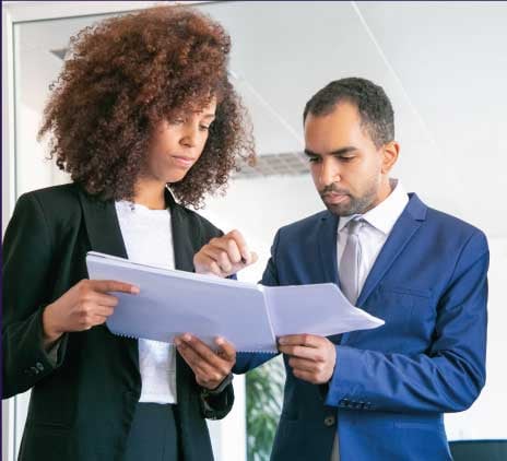 Empregadores de escritório confiantes verificando documentos juntos. Três trabalhadores profissionais focados segurando papéis e assinando relatórios estatísticos na sala de reuniões. Conceito de trabalho em equipe, negócios e gestão